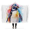 Colorful watercolor style penguin design on a white blanket held by a person.  