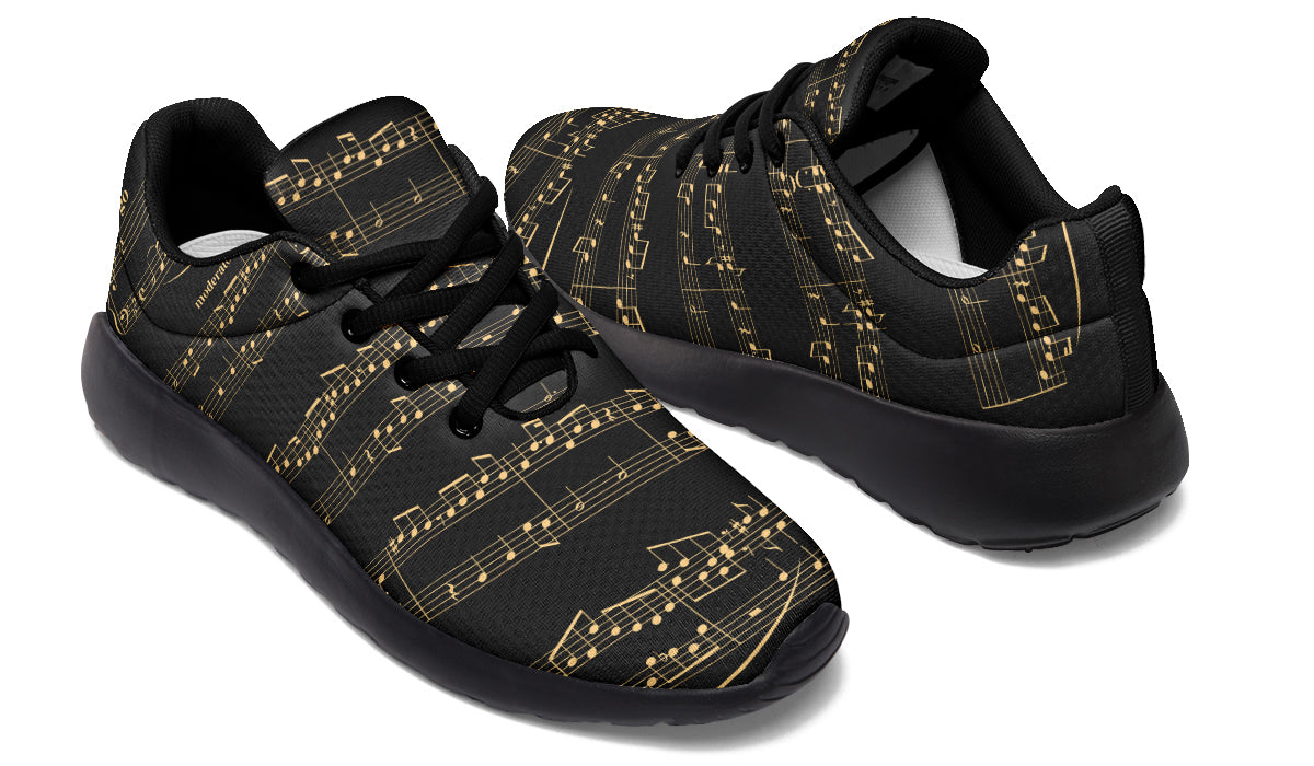 Black sneakers with gold musical note pattern on a white background